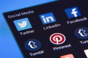 Closeup of a phone screen showing social media icons. Visible are icons for Twitter, LinkedIn, Facebook, Tumblr, and Pinterest